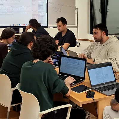 Equipo de marketing reunido en una mesa con varios portátiles